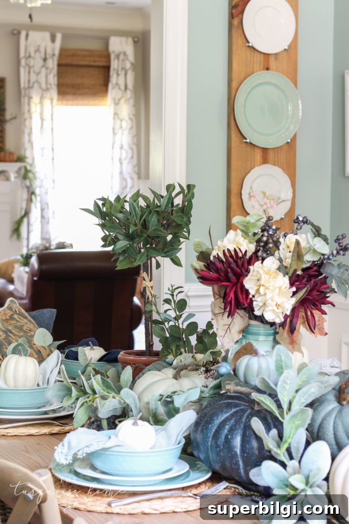 Pumpkins and Greenery Fall Tablescape Ideas 6 Pumpkins and Greenery Fall Tablescape with bay leaves in a pot and fall floral arrangement.