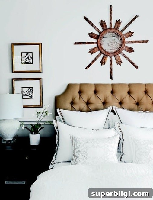 sunburst mirror hanging on the wall above a bed