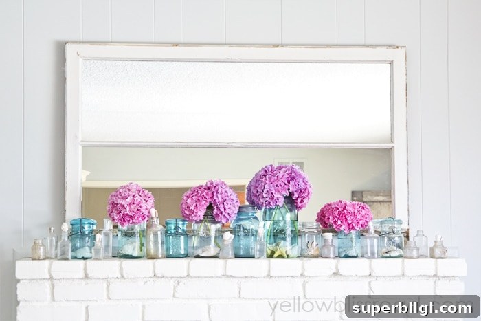 25+ Summer Fireplace Mantel Decor Ideas to Refresh Your Hearth 3 bright pink blooms and blue jars in front of a mirror on a mantel