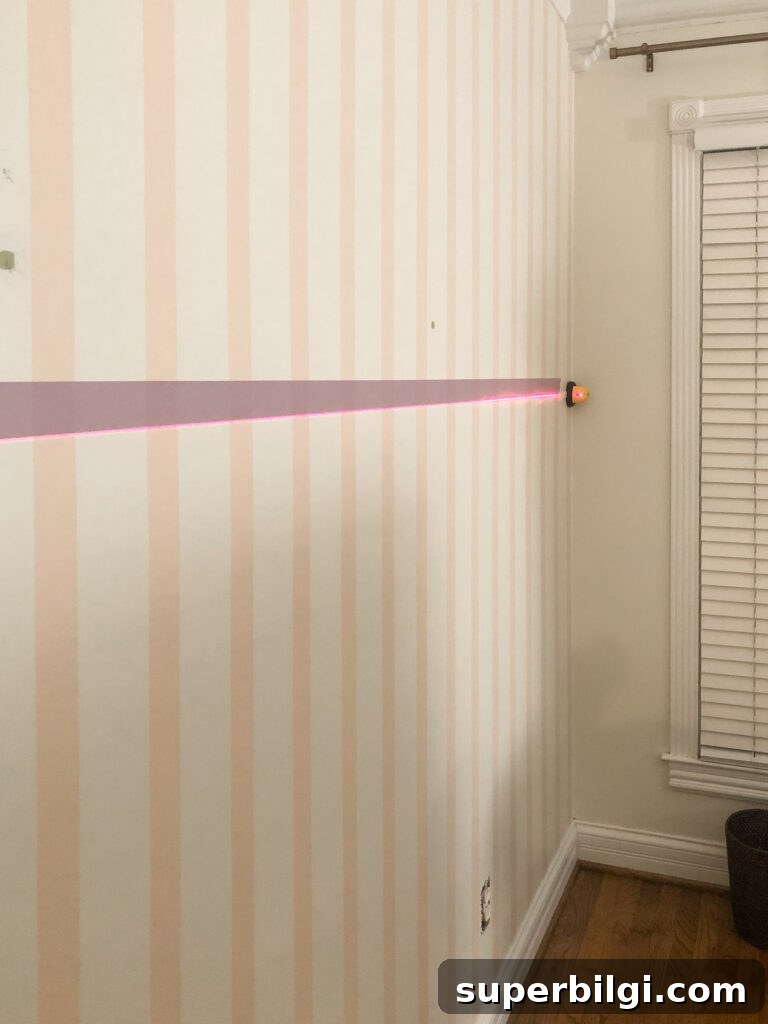 Step-by-Step DIY Plaid Accent Wall Tutorial 9 Laser level on striped wall