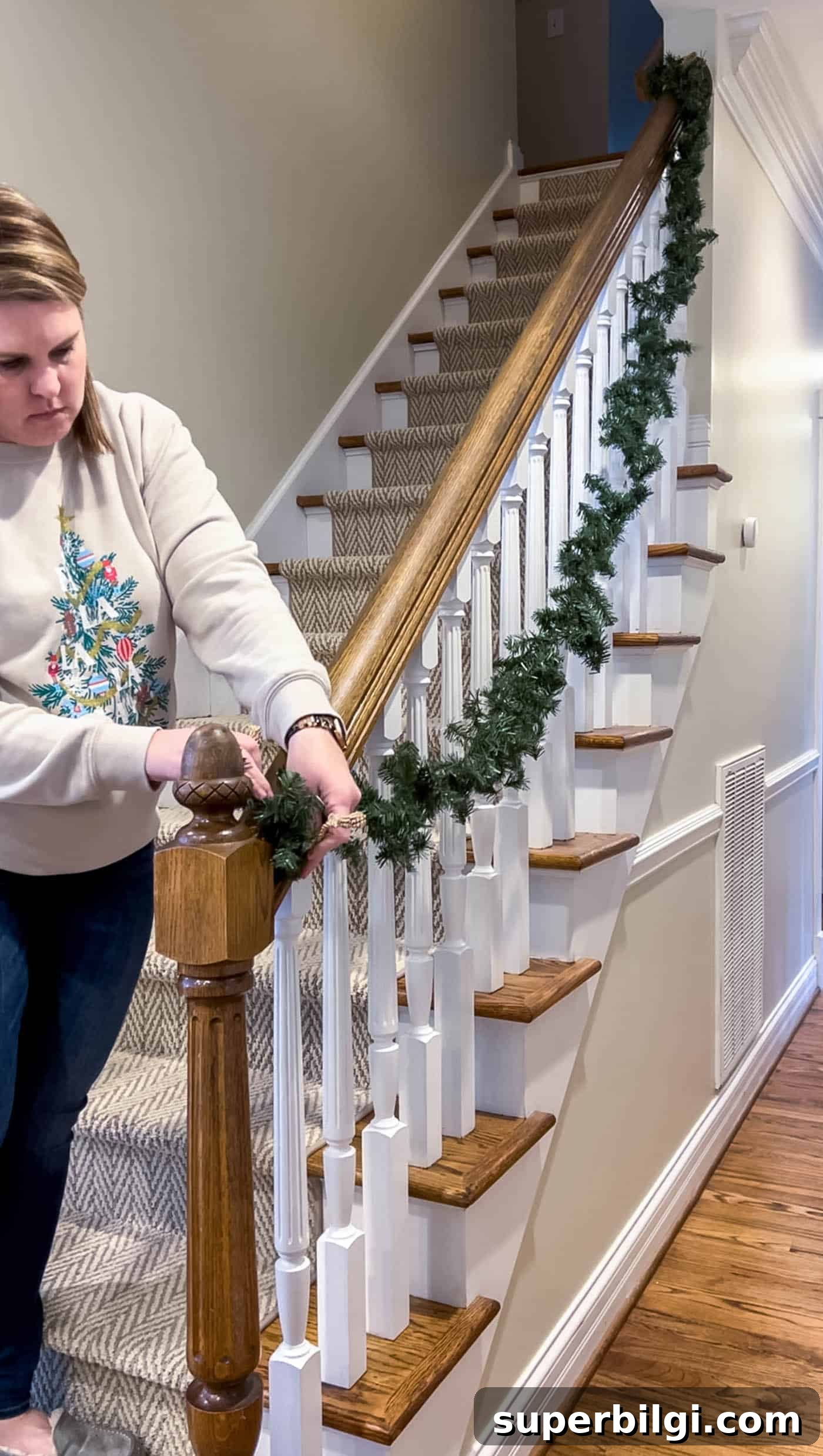 How to Hang Garland on a Staircase or Banister 6 Hang the first garland on the stairs