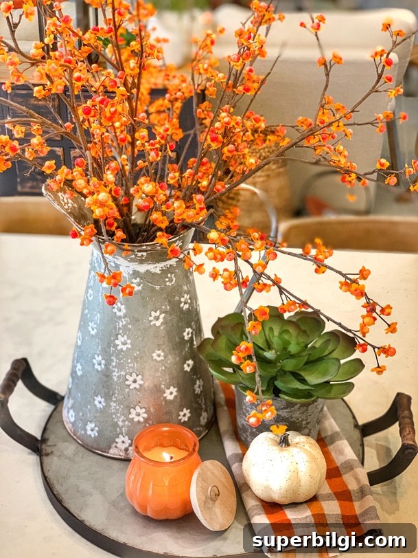 Stylish Fall Centerpiece Ideas for a Warm, Inviting Home 16 Fall flower arrangement with bittersweet branches, succulent, pumpkin, candle