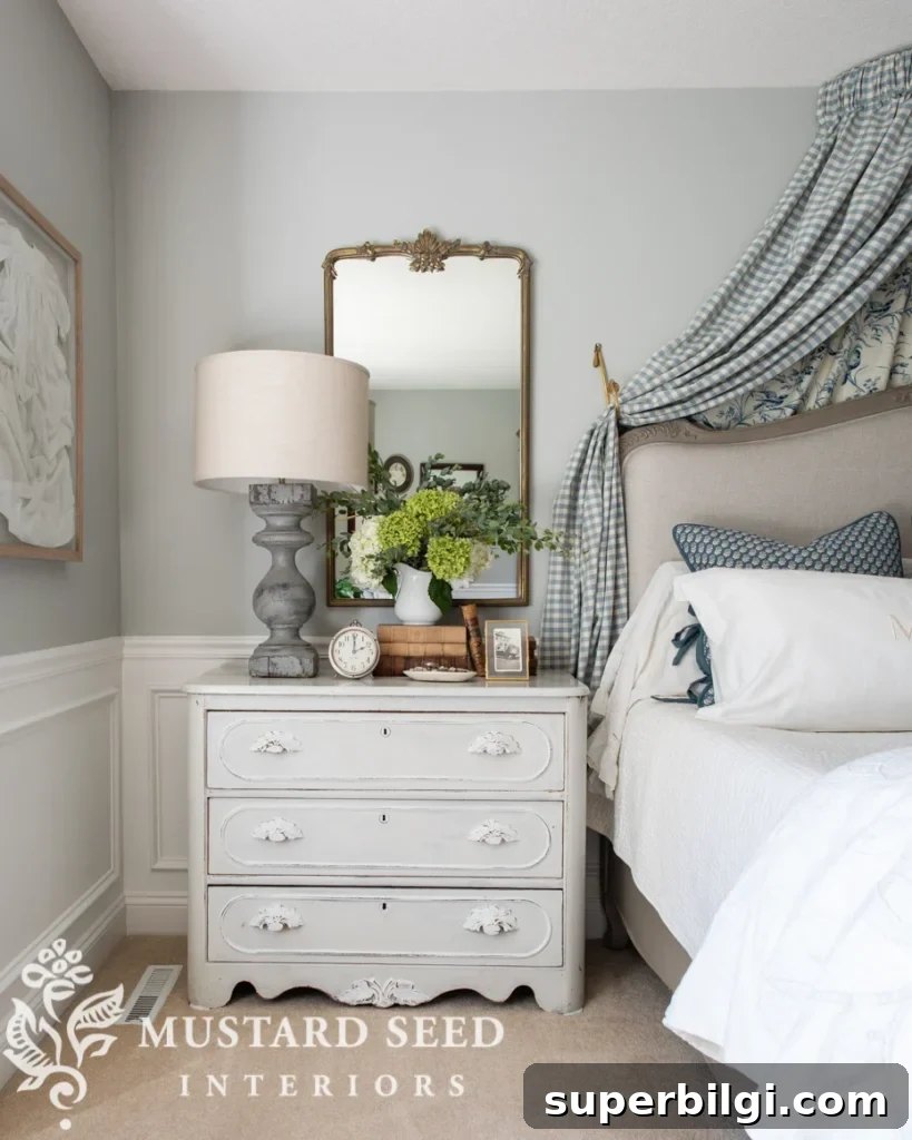 Benjamin Moore Stonington Gray Paint Color: Swatches & Hex Code 4 Primary bedroom with gray walls, fabric valance over the bed, antique painted dresser and an antique mirror.
