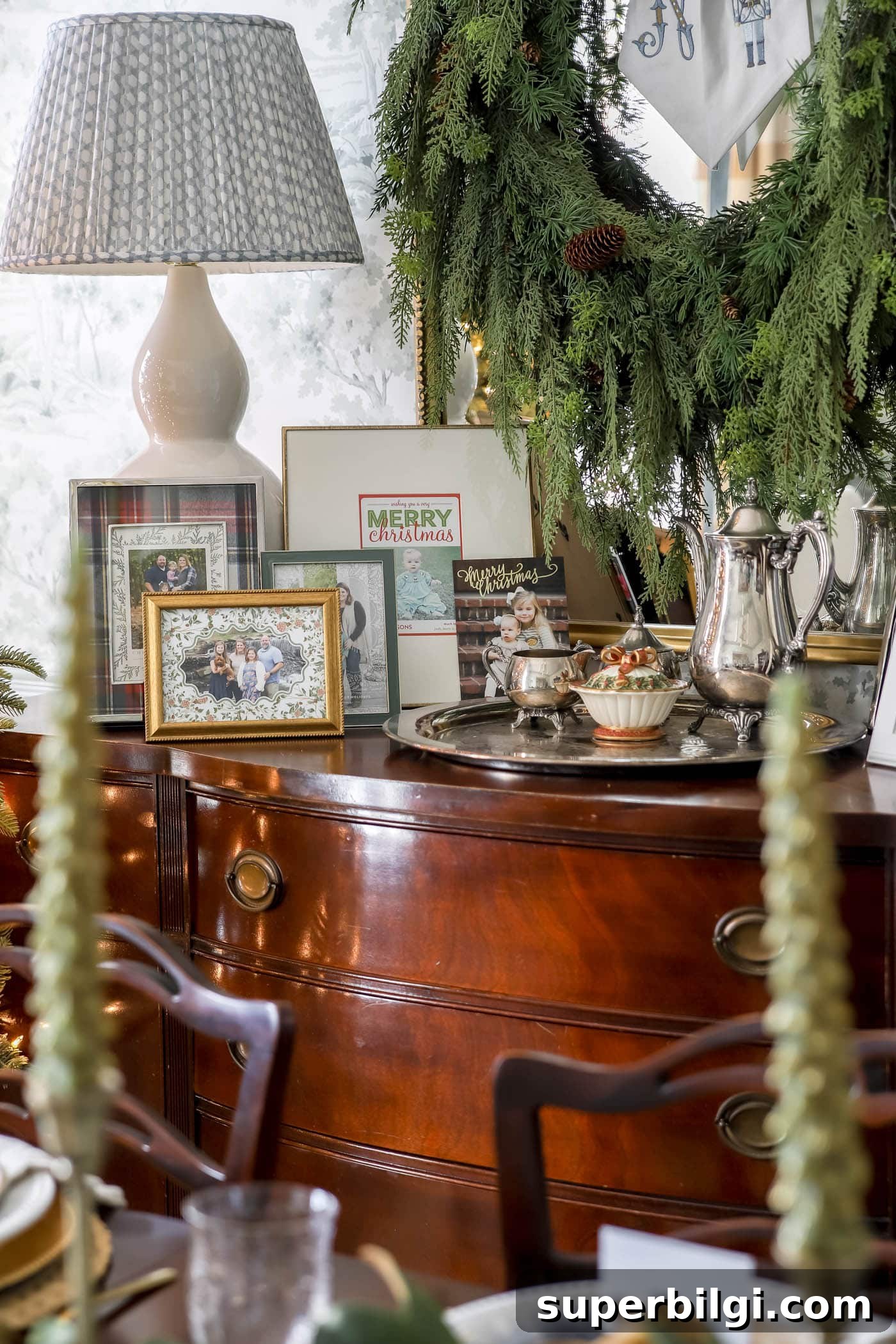 Christmas dining room buffet with framed Christmas cards displayed.