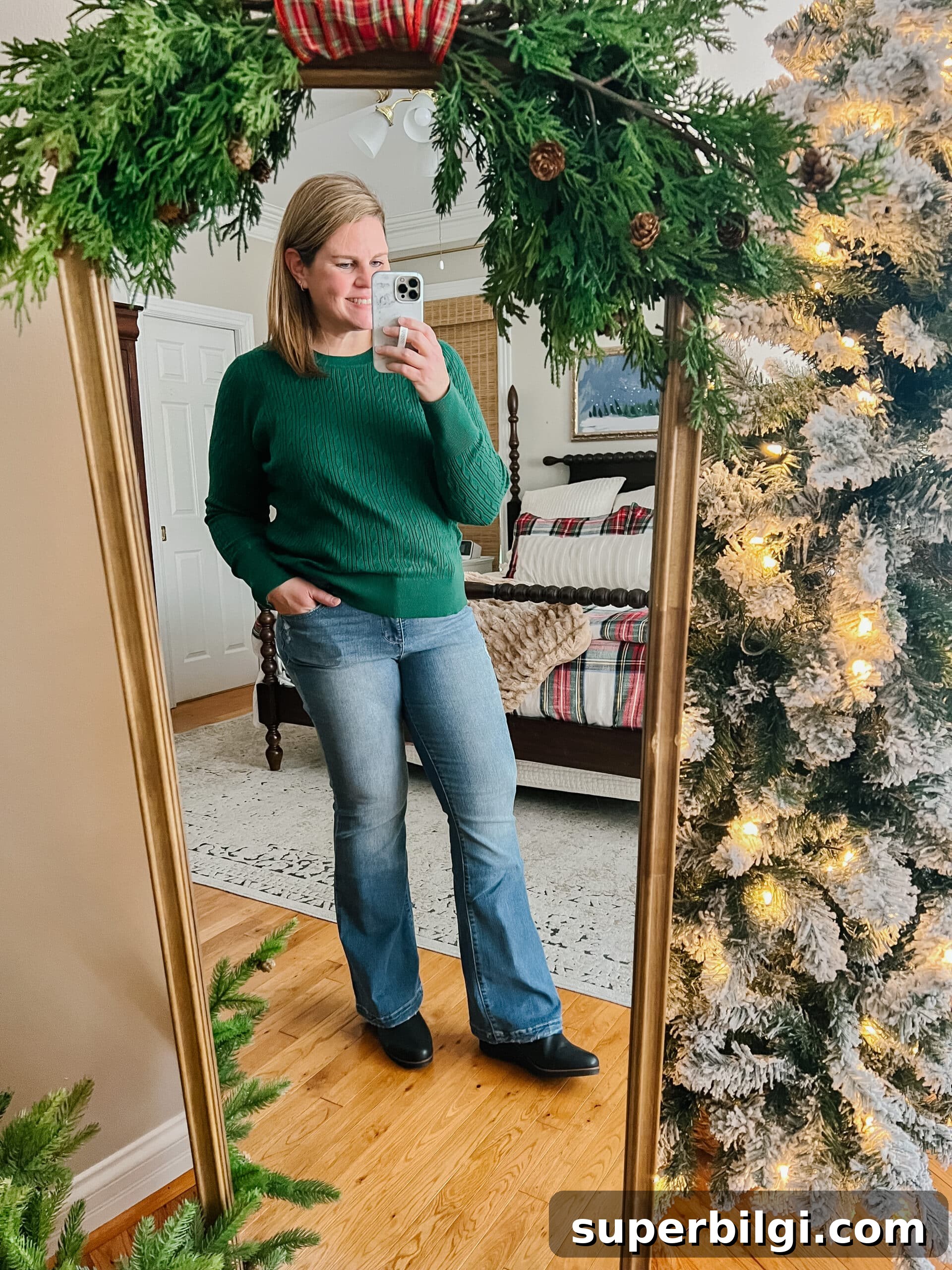 Affordable Winter Jeans and Cozy Sweaters 3 green sweater, jeans, boots outfit in a Christmas bedroom