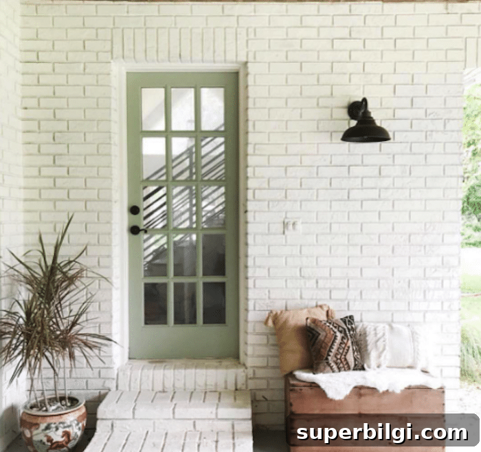 white brick exterior with Sherwin Williams Clary Sage painted door.