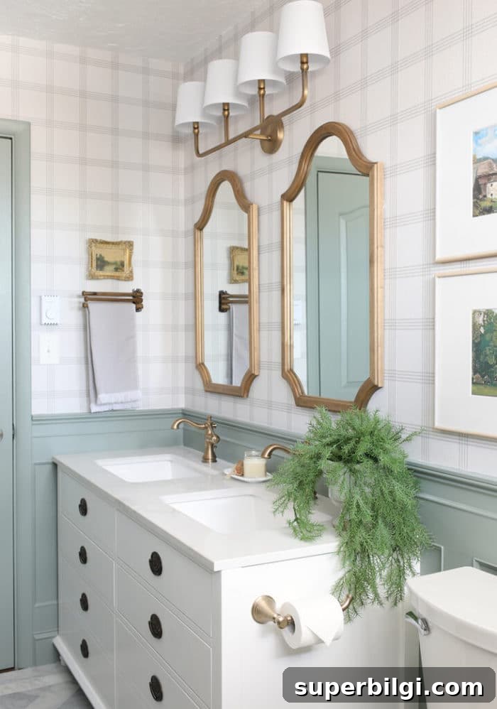 modern bathroom with white vanity and half wall painted Sherwin Williams Acacia Haze and plaid wallpaper on the walls.
