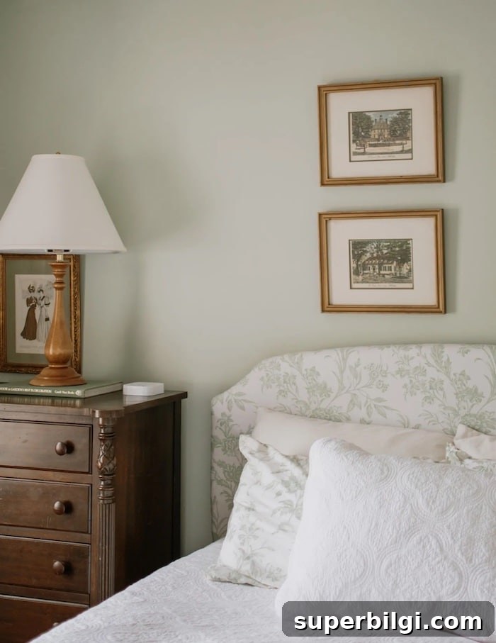 bedroom with Benjamin Moore Hollingsworth Green walls, upholstered bed with toile headboard and dark wood dresser for a nightstand.