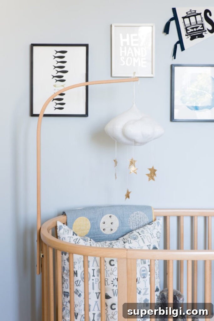 20 Nursery Paint Colors and Accent Wall Ideas for Baby Rooms 11 Blue walls in a boy's nursery with cloud hanging mobile and wall art.