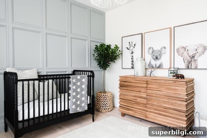 20 Nursery Paint Colors and Accent Wall Ideas for Baby Rooms 13 Wall moulding in nusery painted Boothbay Gray and animal photos on opposite wall with a black crib.
