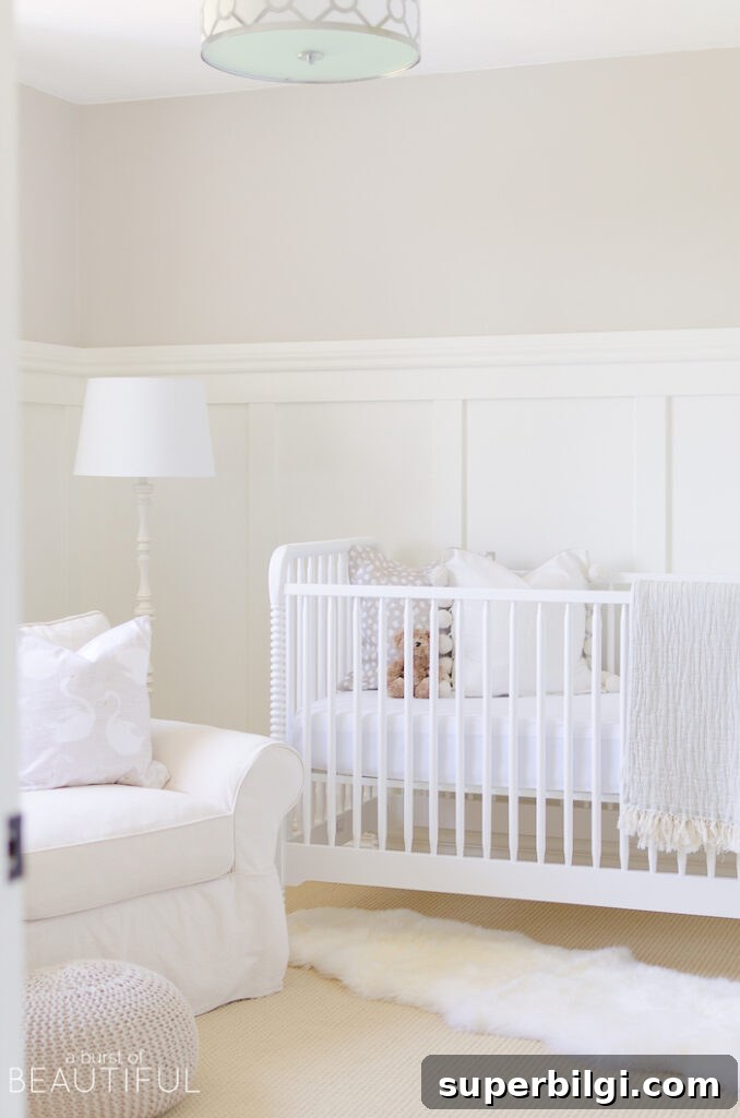 20 Nursery Paint Colors and Accent Wall Ideas for Baby Rooms 18 Neutral nursery with Pale Oak walls, white board and batten, white crib, white lamp and white glider rocker.