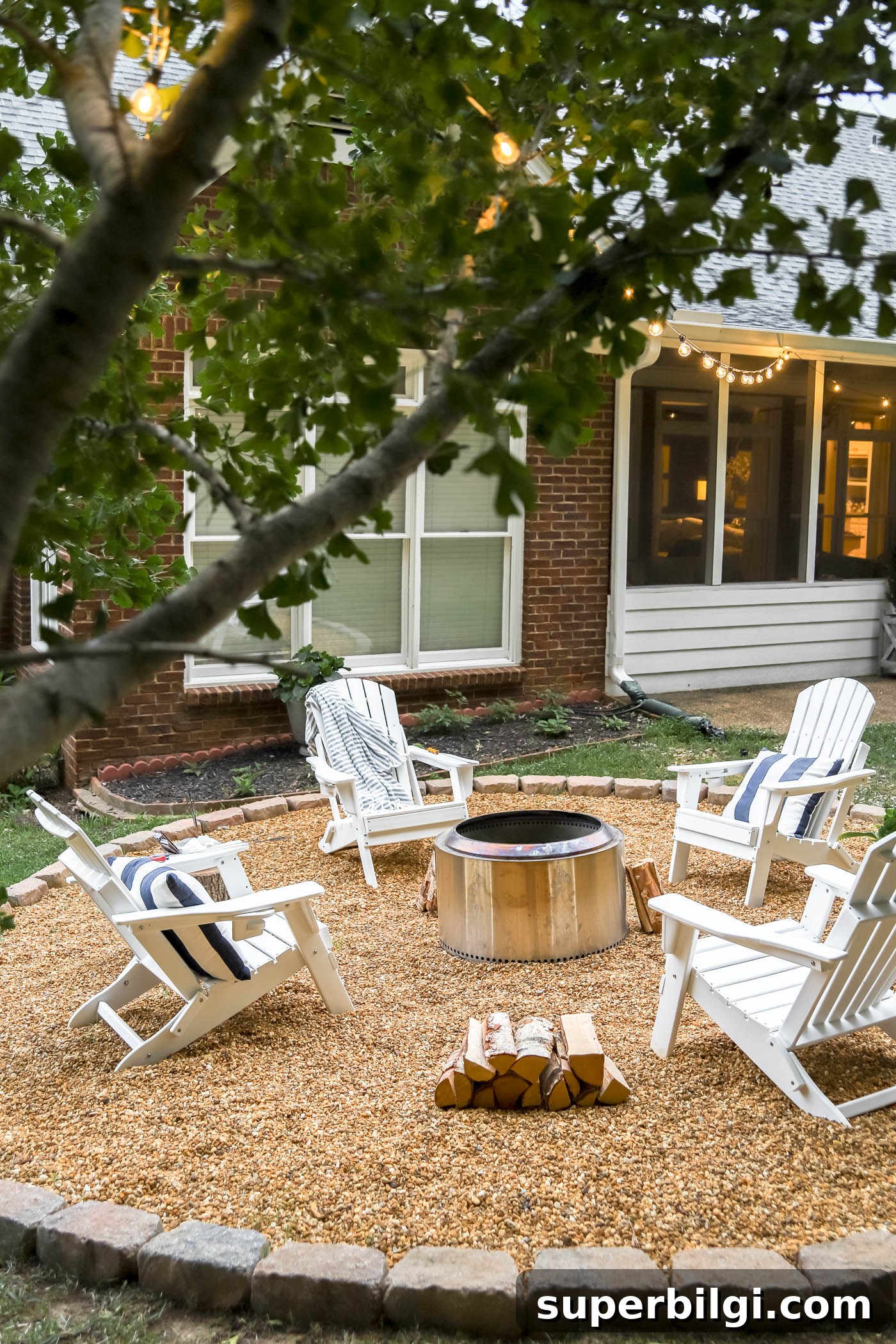 Fire pit area with white adirondack chairs, pea gravel and Yukon Solo Stove.