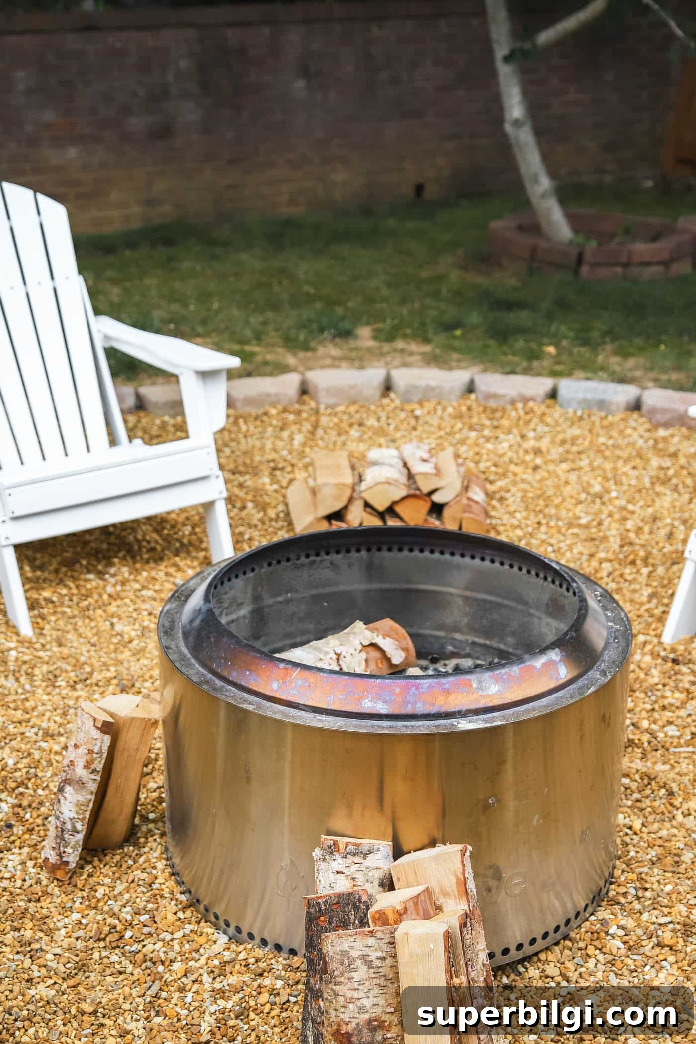 Yukon Solo Stove with fire wood on a pea gravel fire pit.