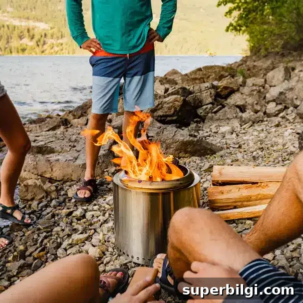 a Solo stove fire pit on a beach with people around it.