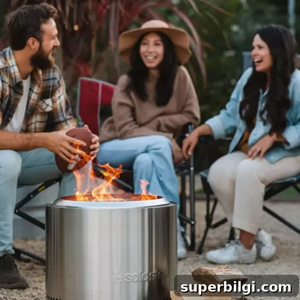 one man and two women sitting in camp chairs around a small Solo Stove fire pit