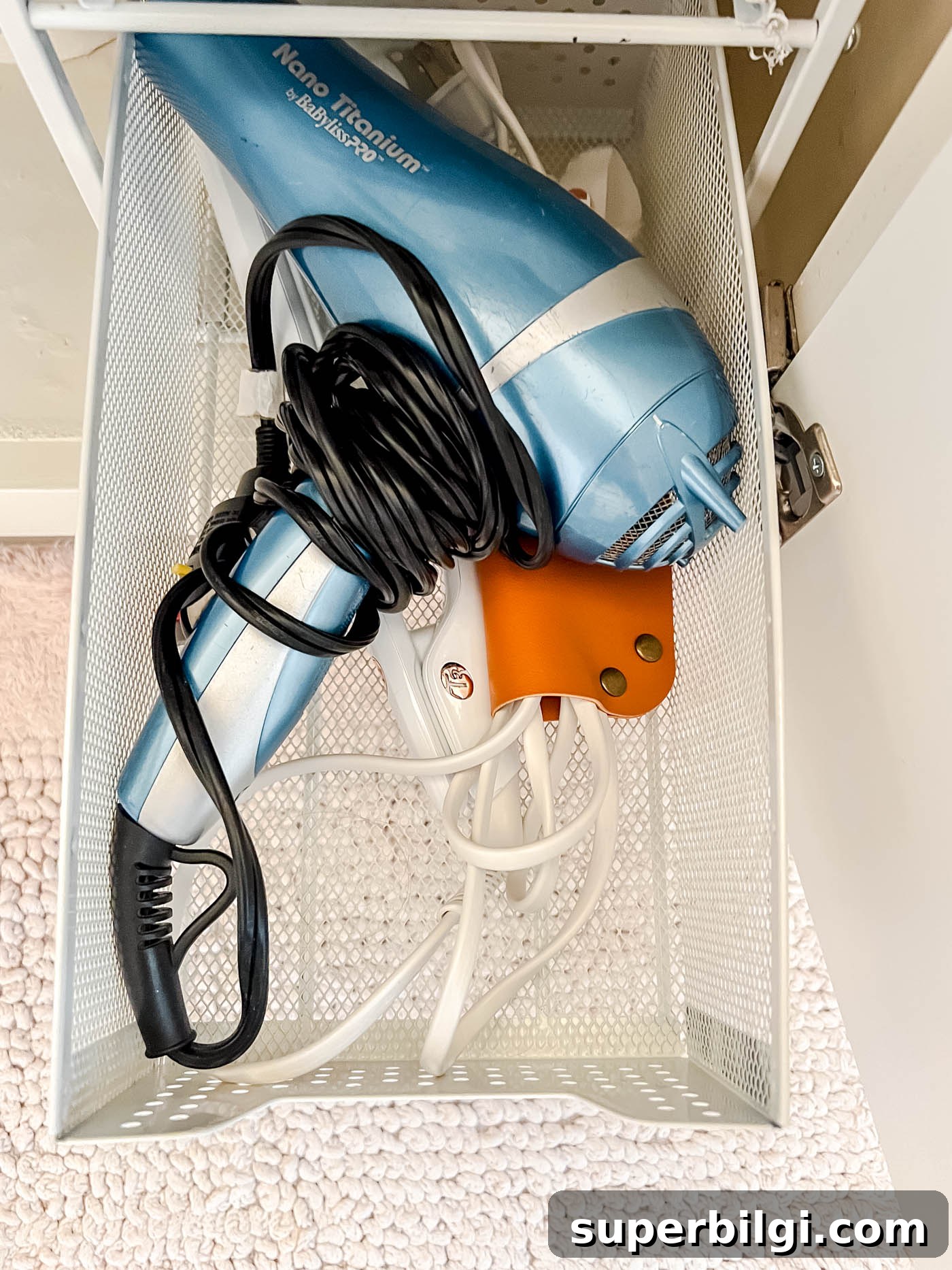 Under-Sink Storage Ideas for Bathroom Organization 5 dryer and straightening irons in the under-the-sink storage.