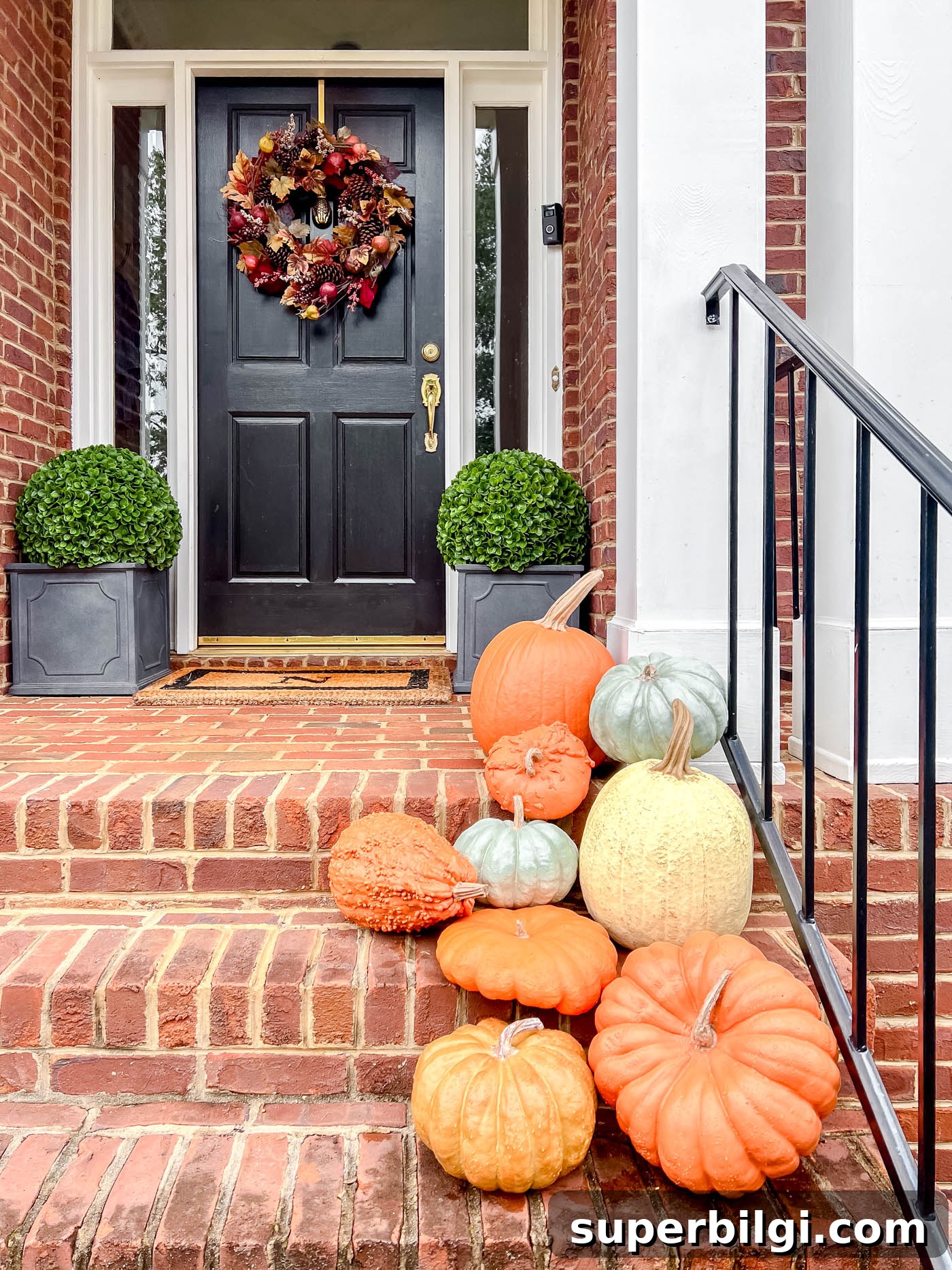 7 Creative Outdoor Fall Decorating Ideas 8 faux pumpkins on a front porch with autumn wreath.