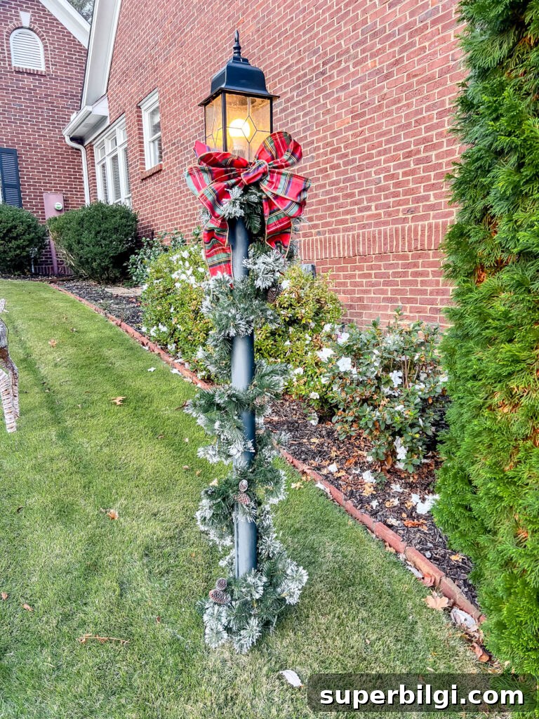 Outdoor Holiday Decor Deals: Lights, Wreaths and Lawn Displays 11 lamppost with holiday garland and red plaid bow.