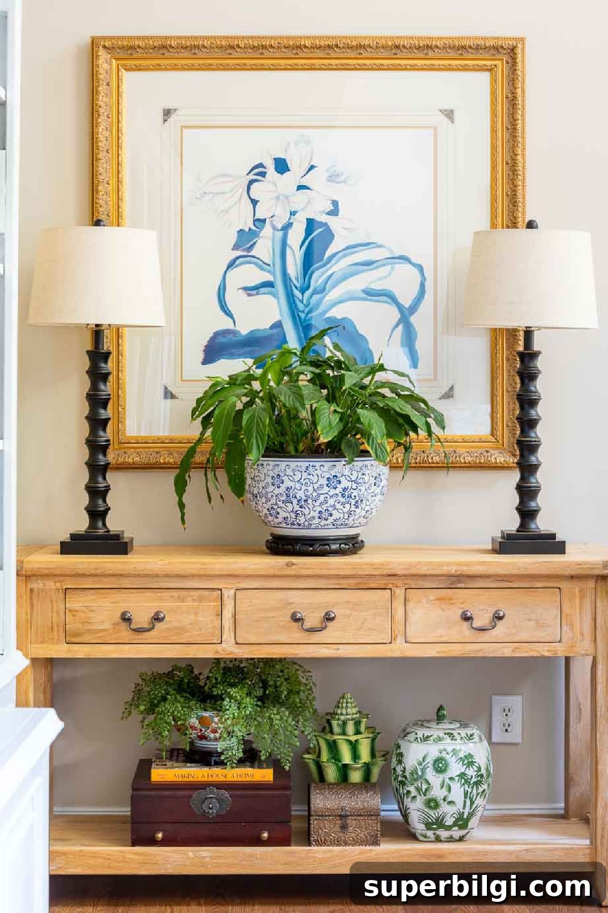 Historic Home Tour: Hydrangeas, Tablescapes and Design Tips 6 wood console table with lamps, wall art behind it and a large potted plant on the middle of the table.