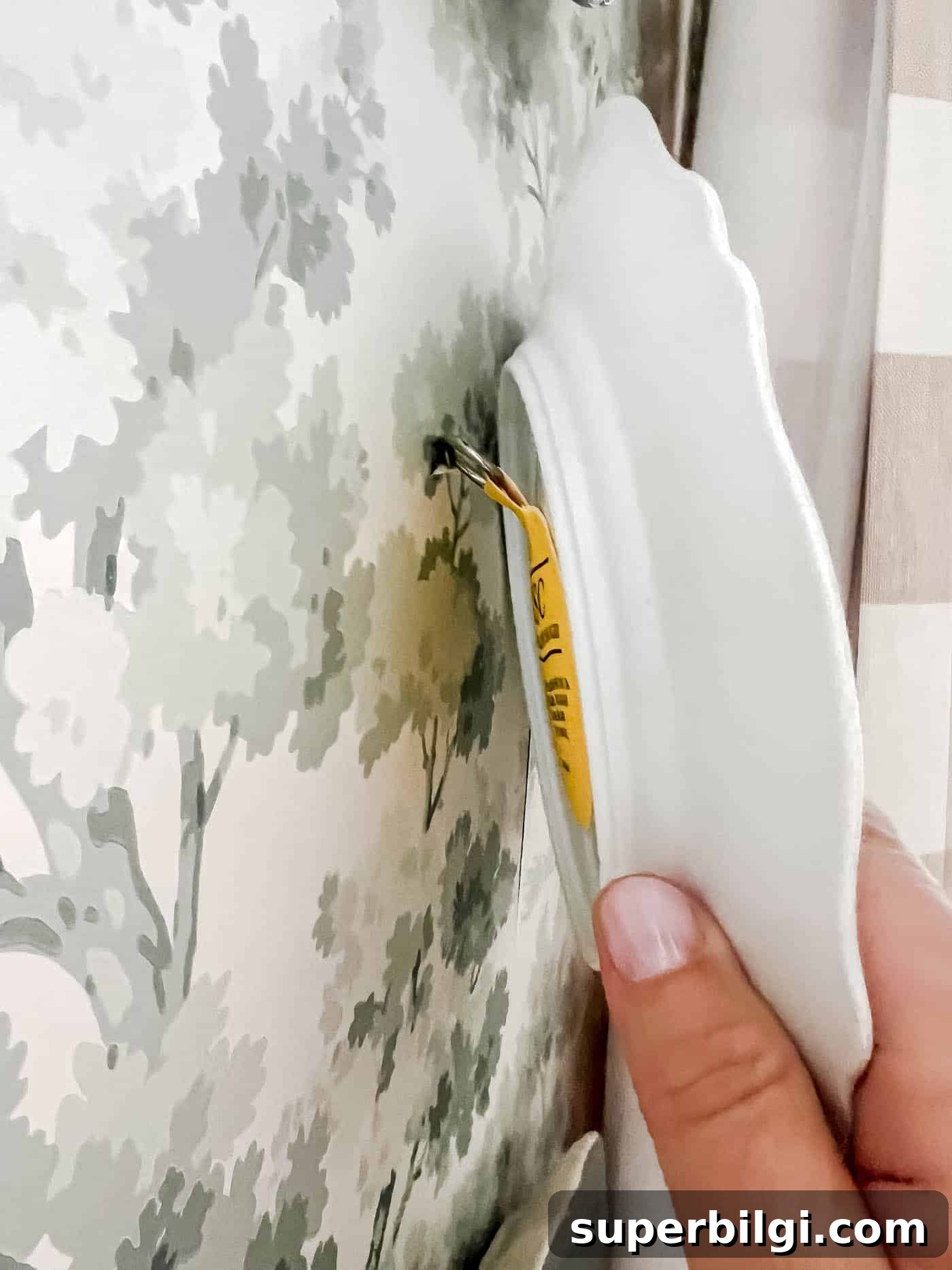 How to Hang Decorative Plates on a Wall Safely 9 Hang a plate on a wall with a screw and adhesive disc.