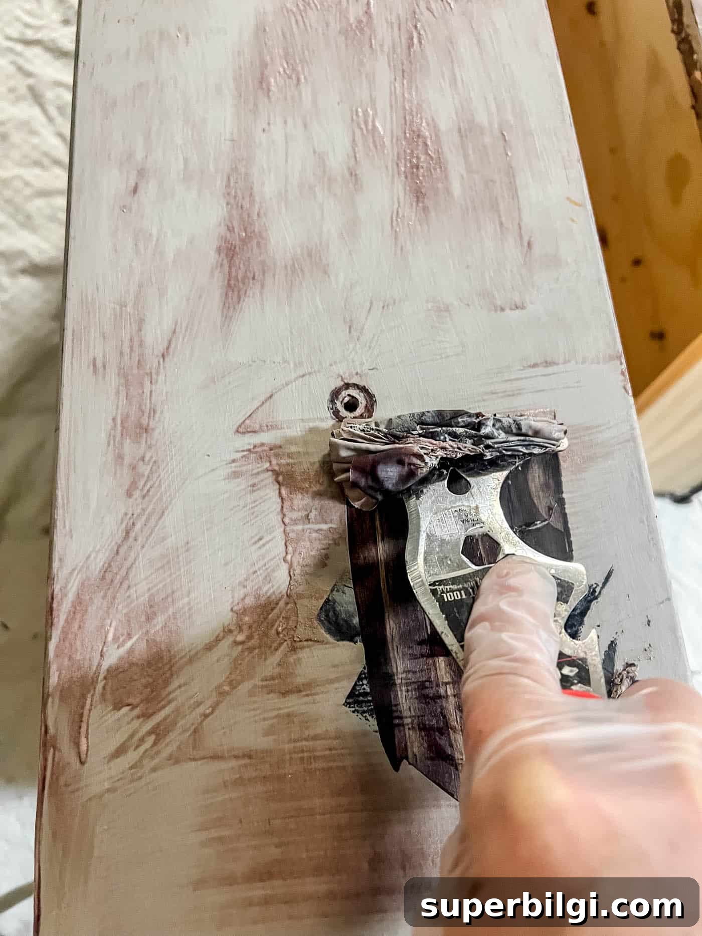 removing paint with a scraping tool.