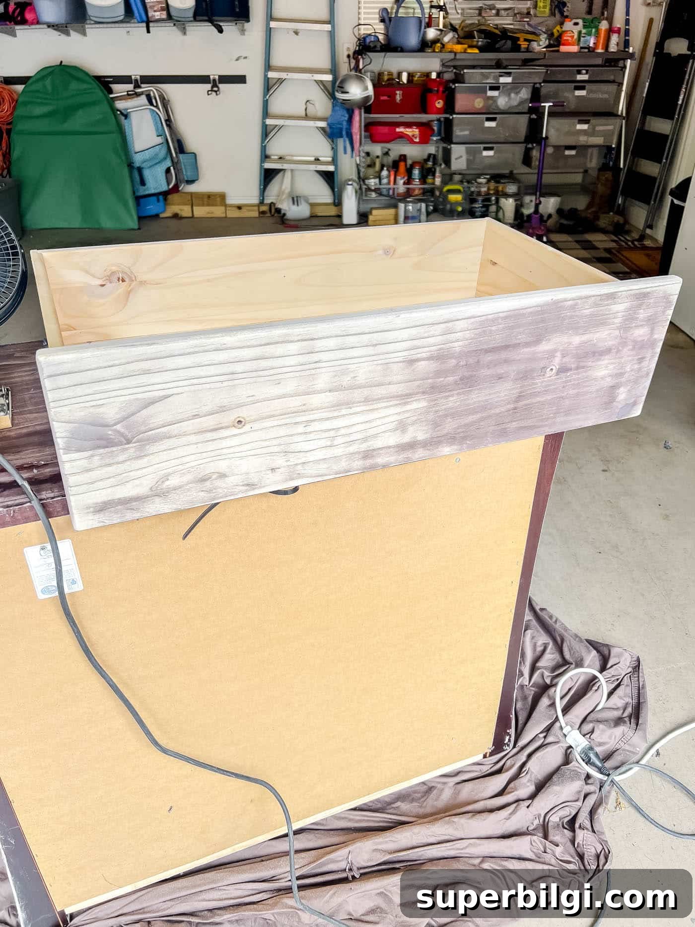 sanding down the drawers with a sheet sander.