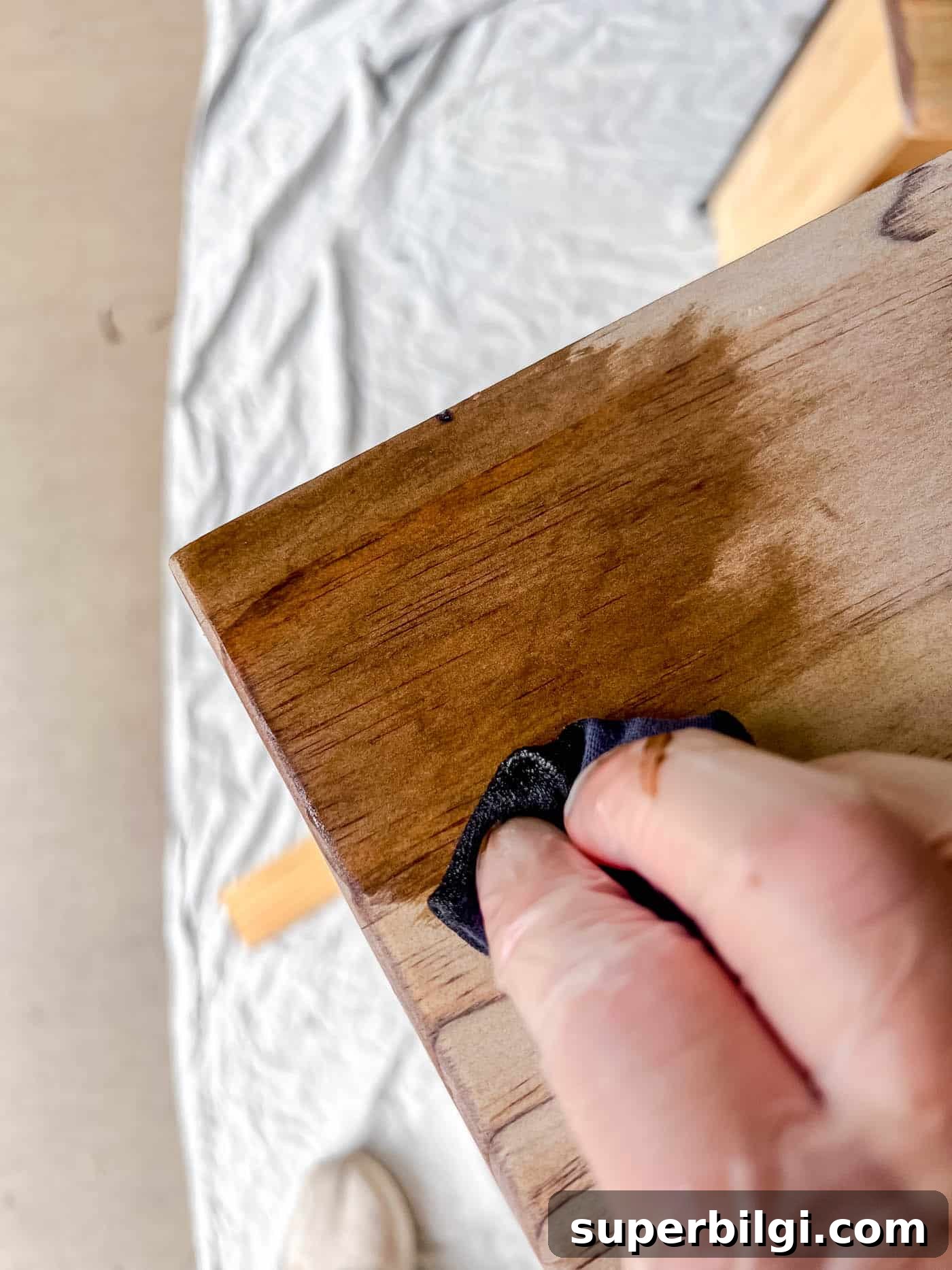 applying stain to a piece of wood furniture.
