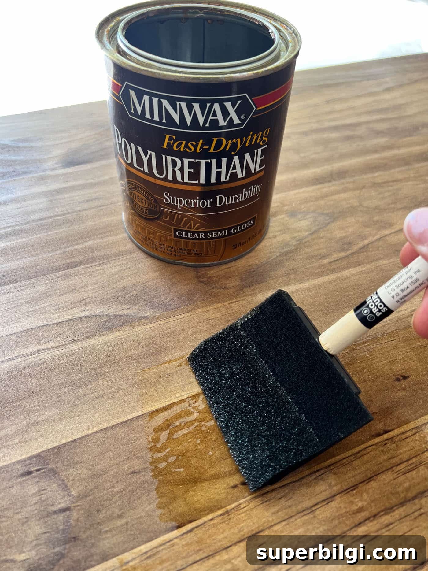 applying a top coat to a newly stained piece of furniture.
