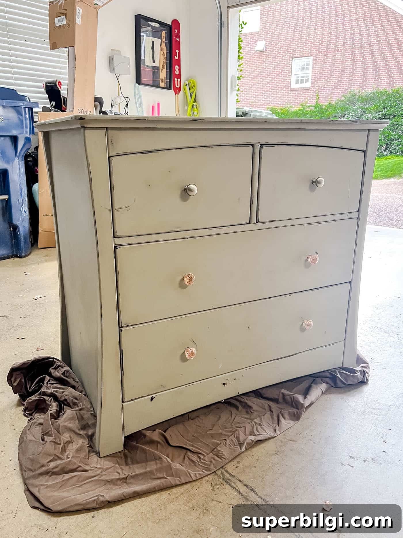 gray chalk painted dresser in garage on an old bed sheet.