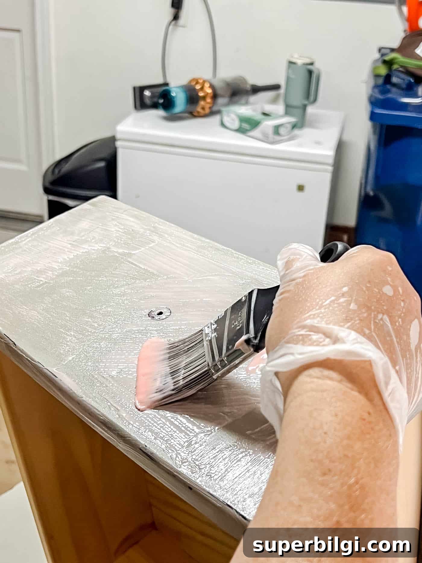 applying chemical stripped to a drawer front to strip the paint.
