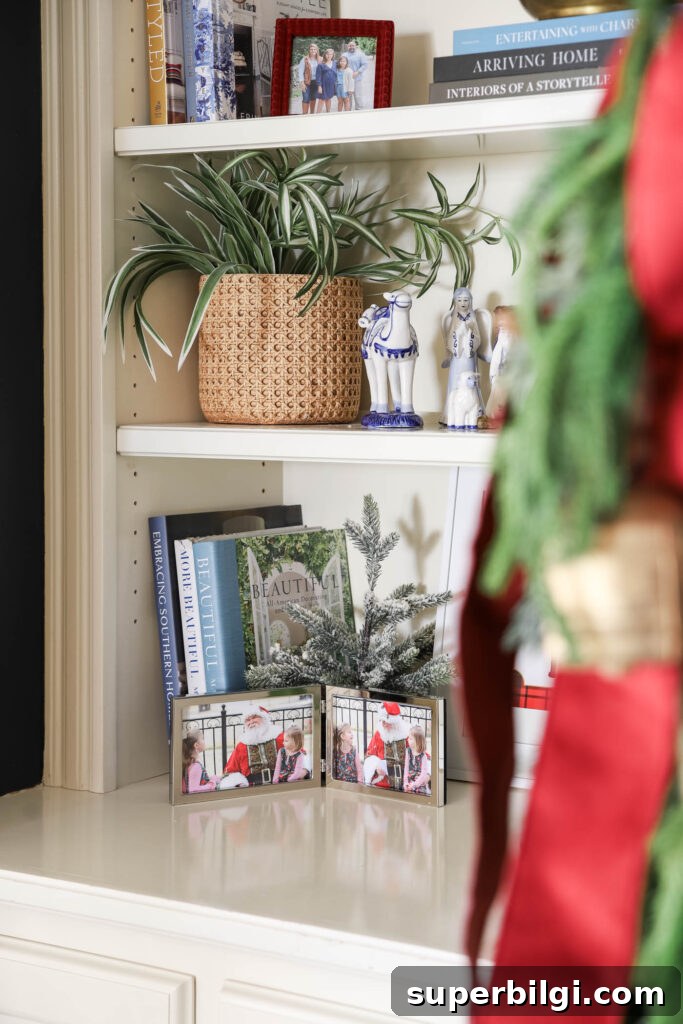Christmas family photo with Santa in silver frame in a bookshelf decorated for Christmas.