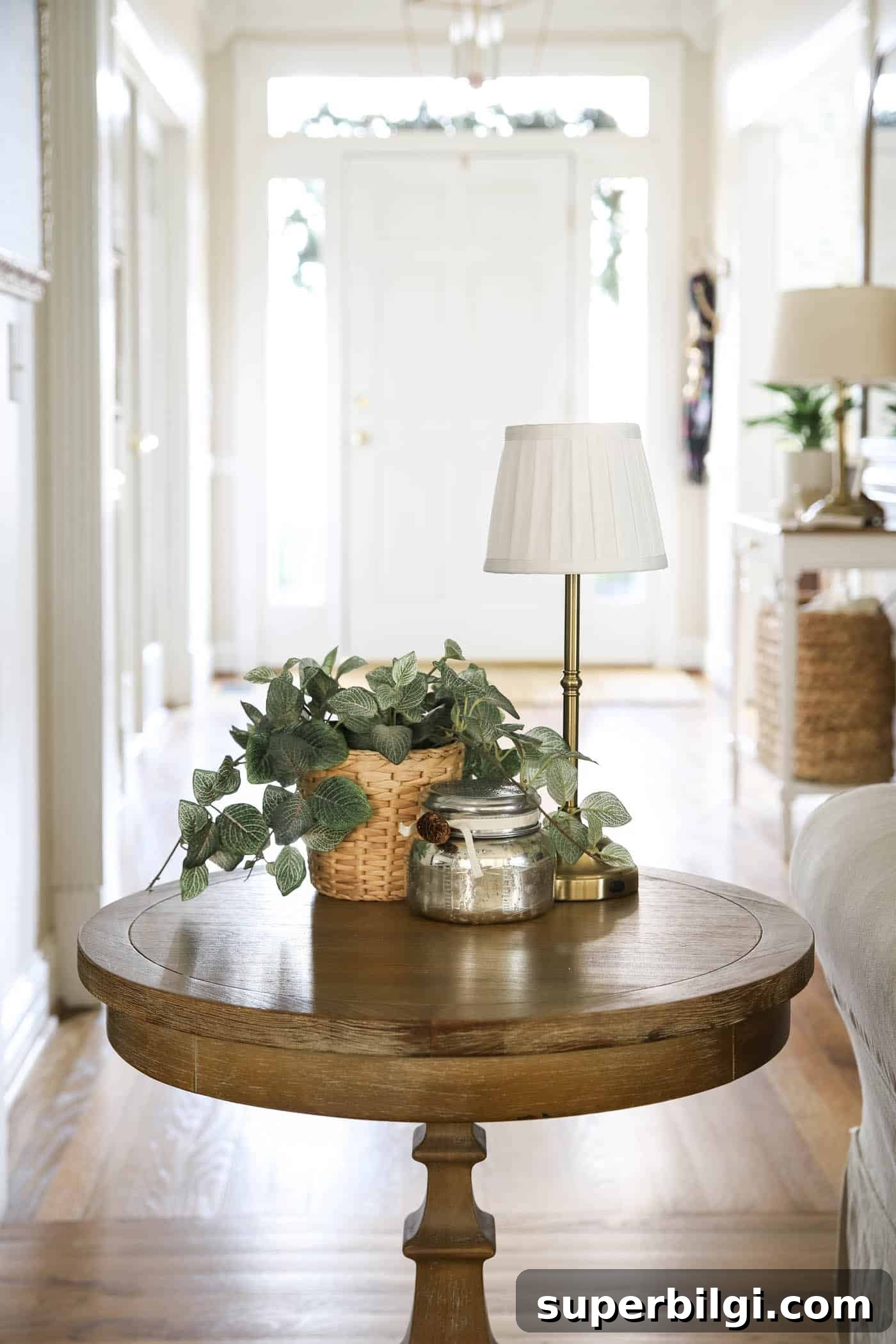 Mini cordless lamp on an end table with greenery and a candle.