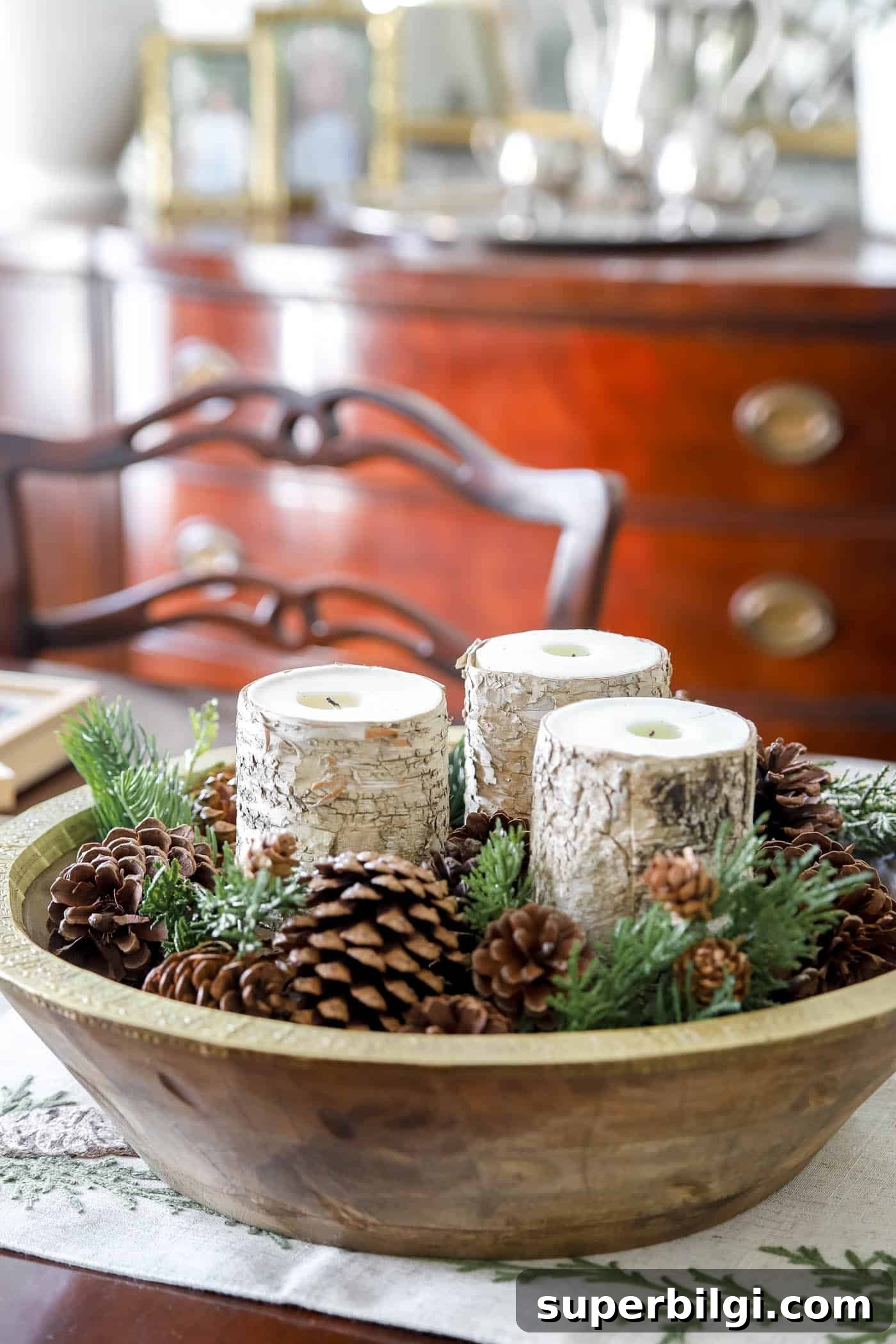 winter pinecones and pops of greenery in a large bowl with candles.