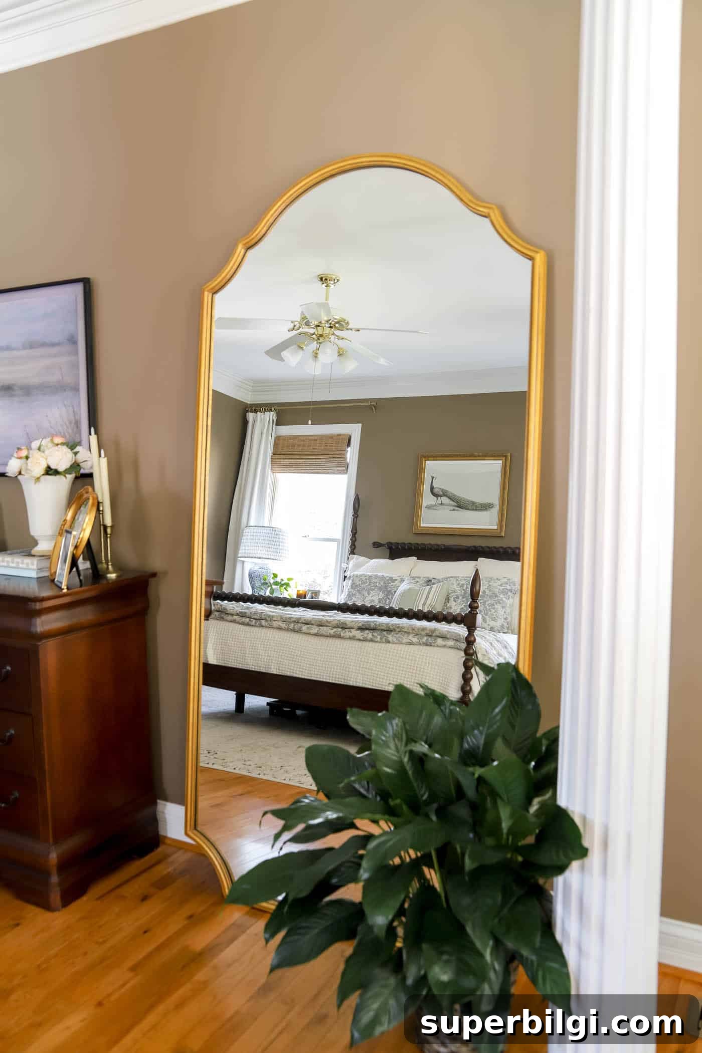 Spring Bedroom Decor Ideas to Instantly Refresh Your Space 5 peace lily next to a large mirror with the reflection of a bed.