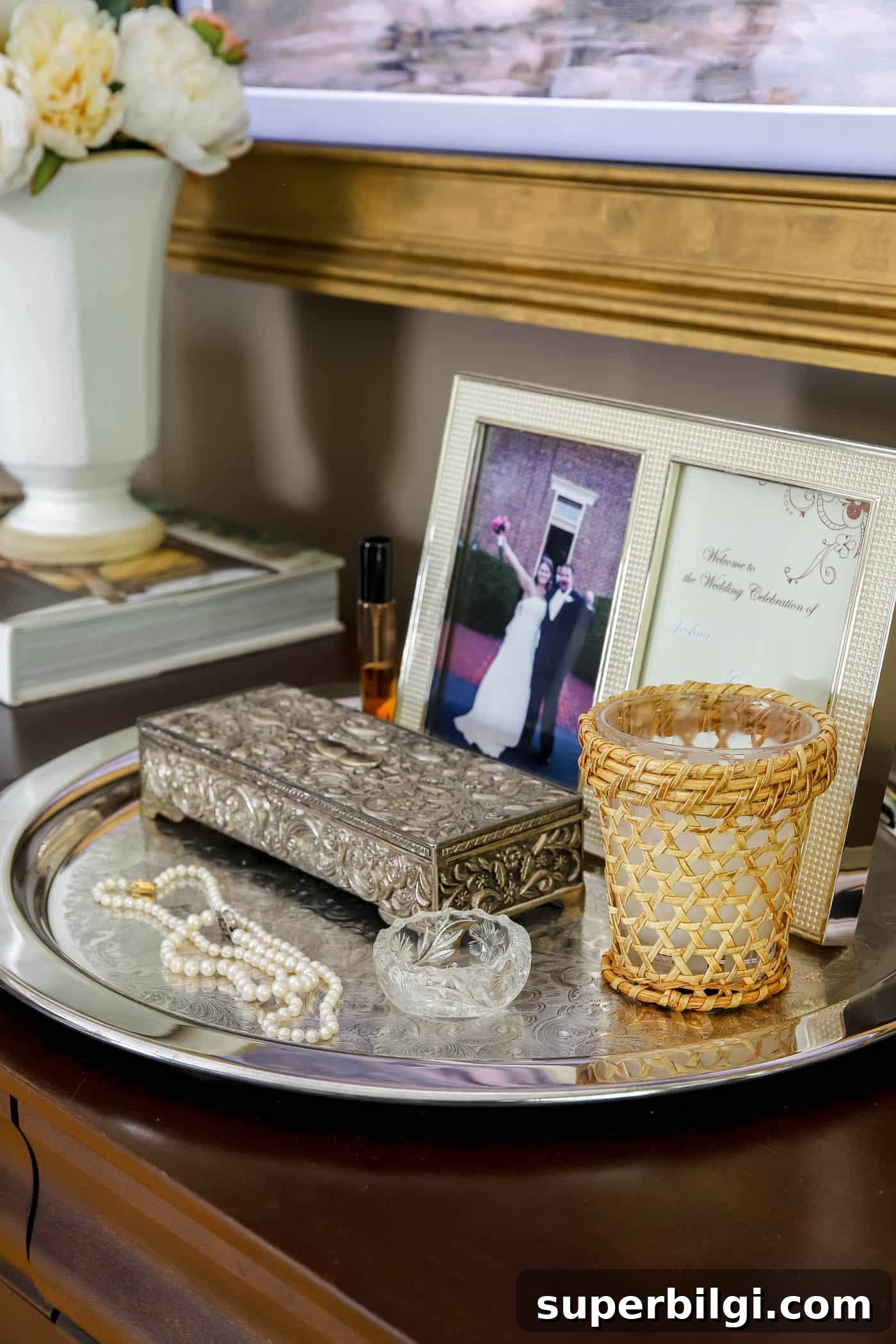 Use and Collect Inherited Antique Silver for Home Decor 12 silver tray on a bedroom dresser holding a framed photo, jewelry box and pearl necklaces.