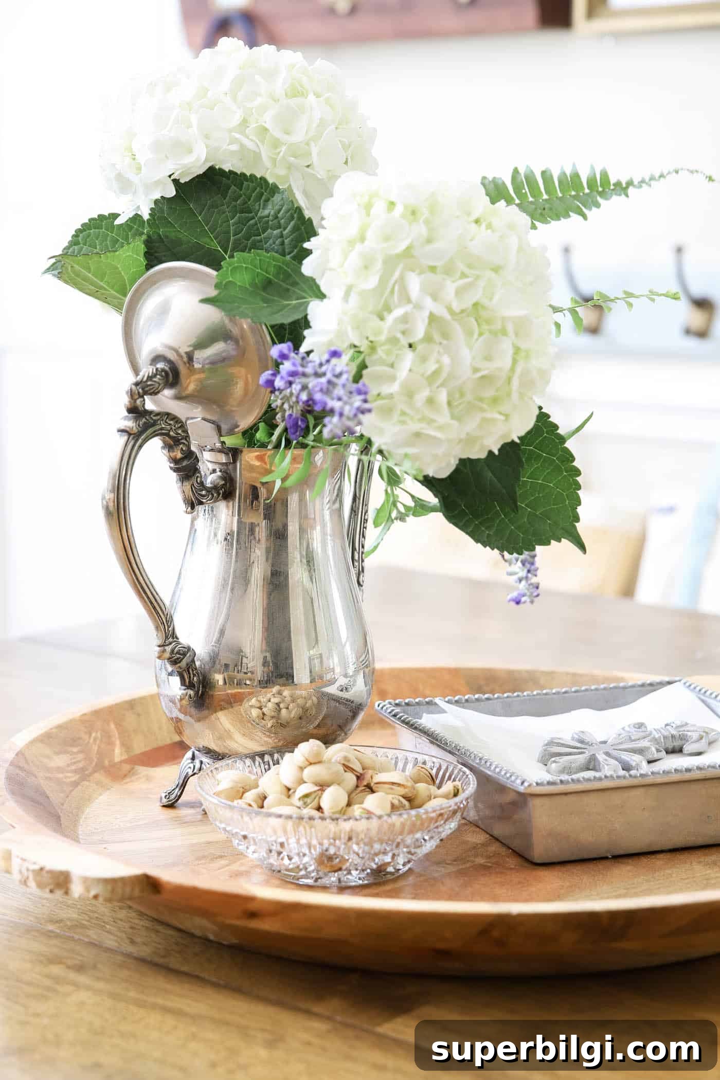 Use and Collect Inherited Antique Silver for Home Decor 4 silver coffee pot as a flower vase on a kitchen table.